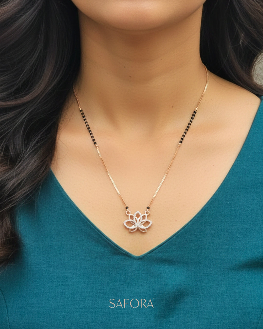 Woman wearing a delicate necklace with a floral pendant, set against a teal background.